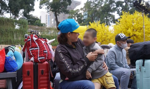 Chị Hoàng Thị Nga cùng chồng và con  về quê đón Tết nhờ chương trình Chuyến xe mùa Xuân. Ảnh: Phương Ngân