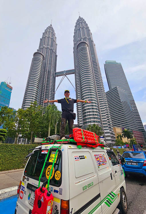 Trần Đặng Đăng Khoa và chiếc Suzuki Blind Van - bạn đồng hành trên đường vòng quanh thế giới lần hai - trước Tháp đôi Petronas tại Kuala Lumpur, Malaysia. Ảnh: Nhân vật cung cấp