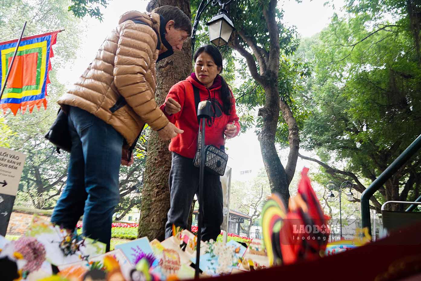 Nhóm du khách nước ngoài mua quà lưu niệm trước cổng Văn Miếu – Quốc Tử Giám.