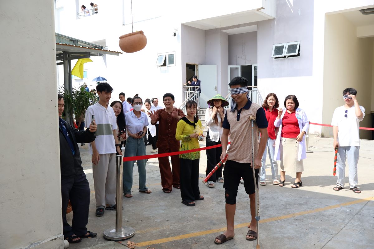 Bệnh nhân mang nạng, tham gia trò chơi đập niêu. Ảnh: Văn Trực