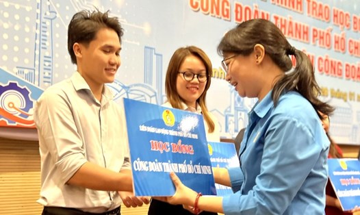 Bà Trần Thị Diệu Thúy - Chủ tịch LĐLĐ TPHCM - trao học bổng “Công đoàn Thành phố Hồ Chí Minh” cho các đoàn viên. Ảnh: Đức Long