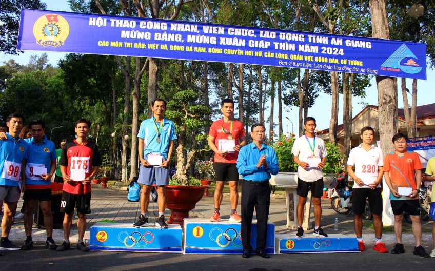 Phó Chủ tịch LĐLĐ tỉnh An Giang Nguyễn Nhật Tiến trao giải cho vận động viên nam cự 2km. Ảnh: Lâm Điền