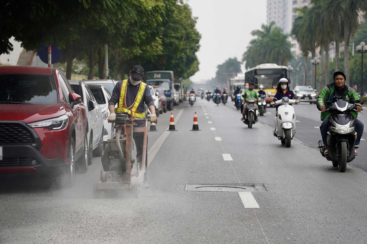 Công nhân đang tiến hành sơn kẻ vạch kẻ đường ở những đoạn còn lại. Ảnh: Hữu Chánh