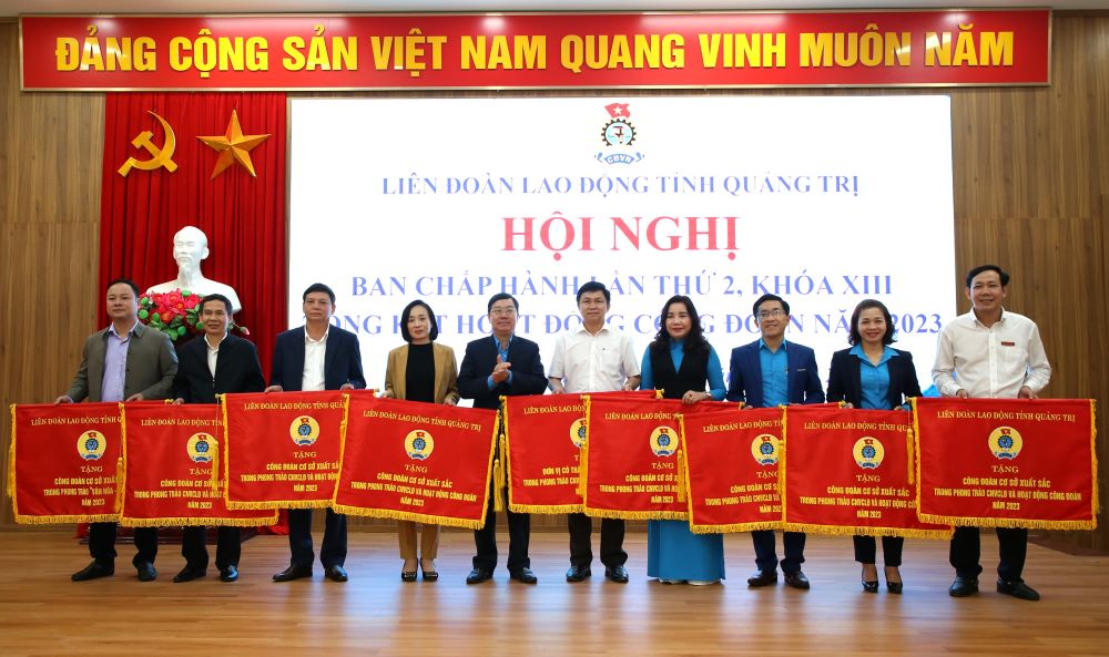 Ông Nguyễn Thế Lập - Chủ tịch LĐLĐ tỉnh Quảng Trị trao Cờ thi đua cho 9 tập thể. Ảnh: Hưng Thơ.