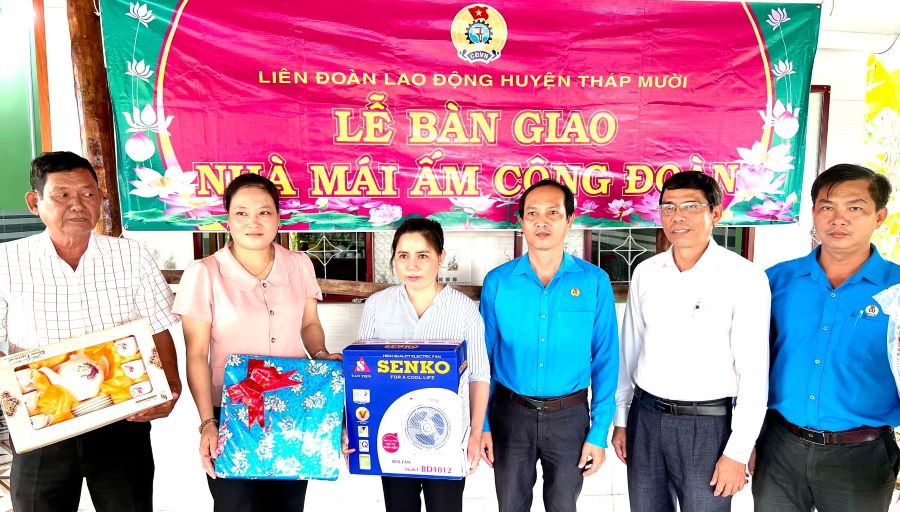 Ông Võ Văn Đổi, Chủ tịch LĐLĐ huyện Tháp Mười cùng chính quyền địa phương trao quà đoàn viên Ngô Thị Cẩm Nhung. Ảnh: Lưu Hùng