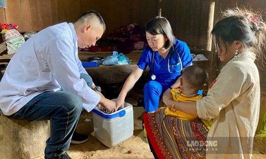 Cán bộ y tế của Trạm Y tế xã Mường Và, huyện Sốp Cộp, Sơn La "cõng" vaccine ngược núi tiêm chủng cho trẻ vùng cao. Ảnh: Phương Hồng