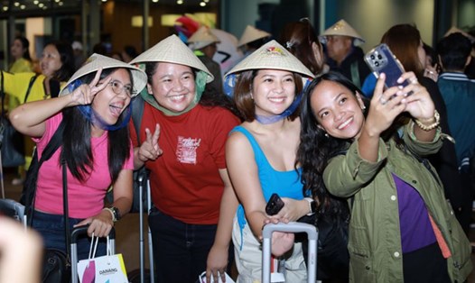 Khách quốc tế tại sân bay Đà Nẵng hào hứng khi được tặng nón lá Việt Nam. Ảnh: Nguyên Thi