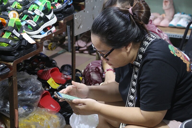 Tại chợ Hoà Khánh, nhiều tiểu thương bấm điện thoại hoặc đọc báo cả ngày vì không có khách đến mua. 