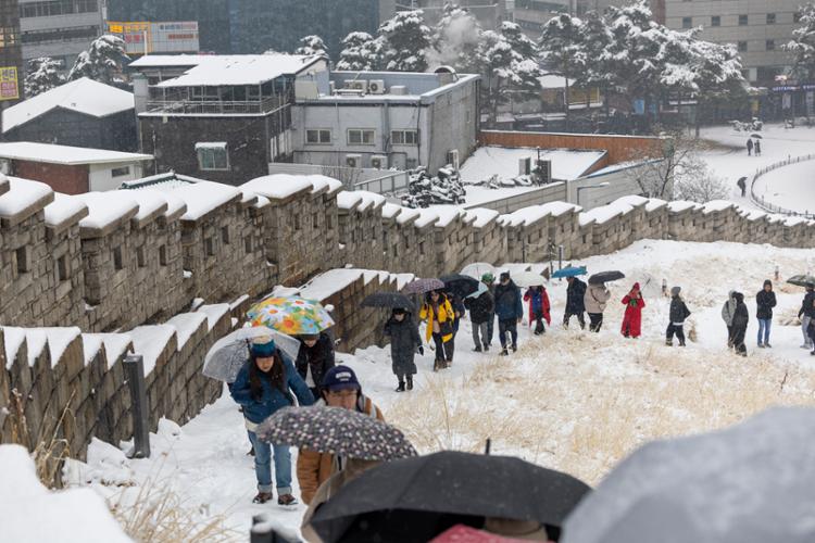 Dòng người đi bộ bên một con phố dốc gần Deoksu, một quần thể cung điện khác ở Seoul có lịch sử hơn 500 năm. Ảnh: Yonhap