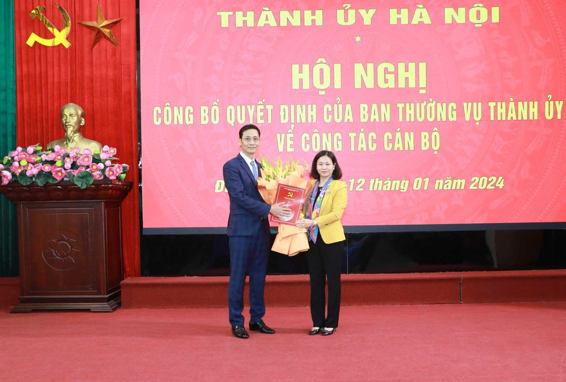 Phó Bí thư Thường trực Thành ủy Hà Nội Nguyễn Thị Tuyến trao quyết định, tặng hoa chúc mừng ông Lê Thanh Nam. Ảnh: Quang Thái