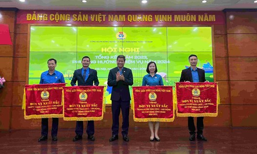 Phó Chủ tịch Tổng LĐLĐVN Huỳnh Thanh Xuân (thứ ba từ trái sang) trao Cờ thi đua của Tổng LĐLĐVN cho các tập thể. Ảnh: Kiều Vũ