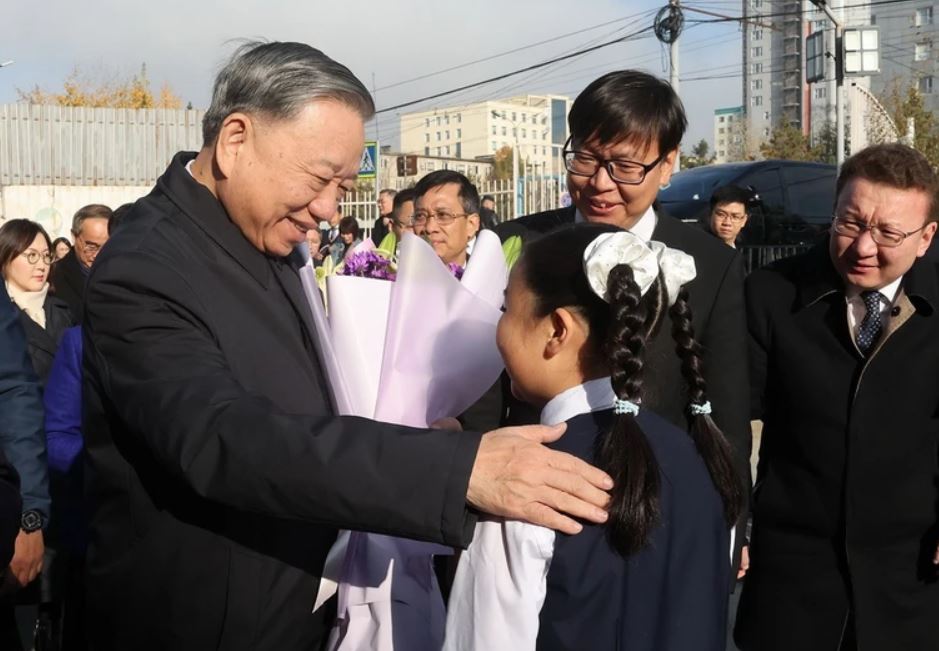 Students of Inter-level School No. 14 present flowers to General Secretary and President To Lam. Photo: VNA