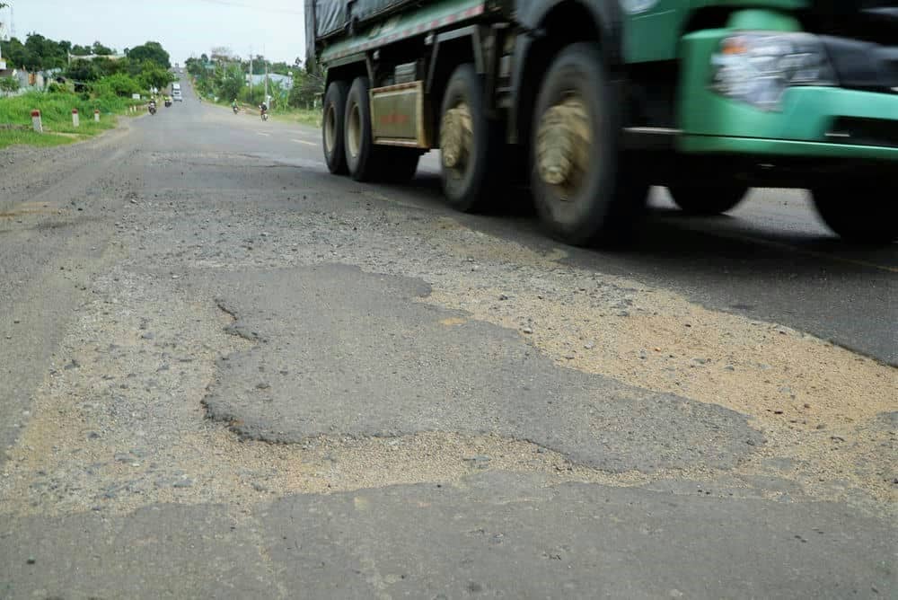 Xe tải lớn cũng phải né vị trí vá đường nham nhở, tránh bị lạc tay lái. Ảnh: Thanh Tuấn  