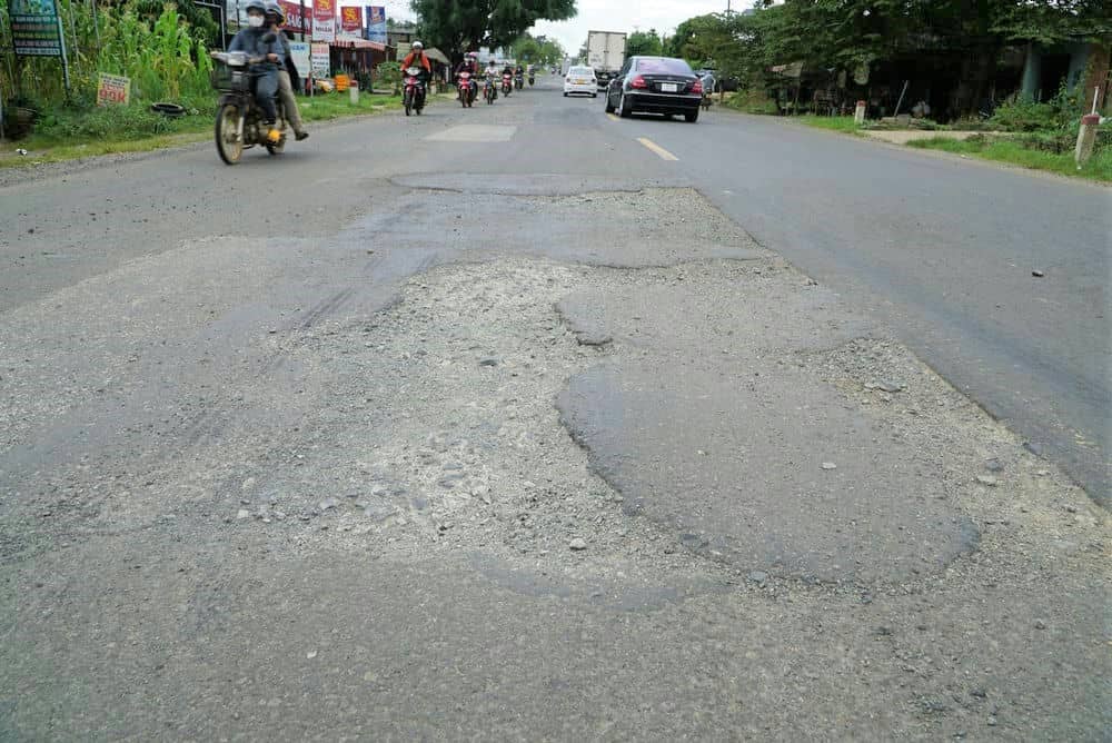 Sau mưa, mặt đường Quốc lộ 14 lại nham nhở, dày đặc vị trí hư hỏng. Ảnh: Thanh Tuấn 