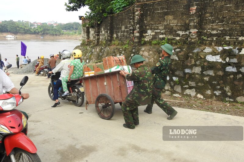 Nhieu nguoi lao dong di chuyen qua cau phao Phong Chau. Anh: To Cong.