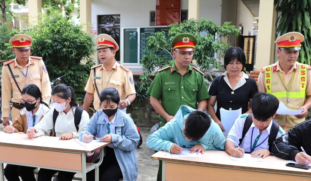 Học sinh ký cam kết chấp hành nghiêm Luật Giao thông đường bộ. Ảnh: Hồng Long