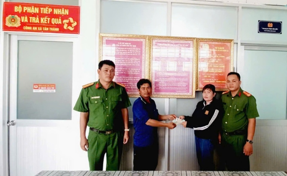 Picking up the wallet with money inside, Ms. Tham (right) asked the police to find the person who dropped it and return it. Photo: Provided by the police