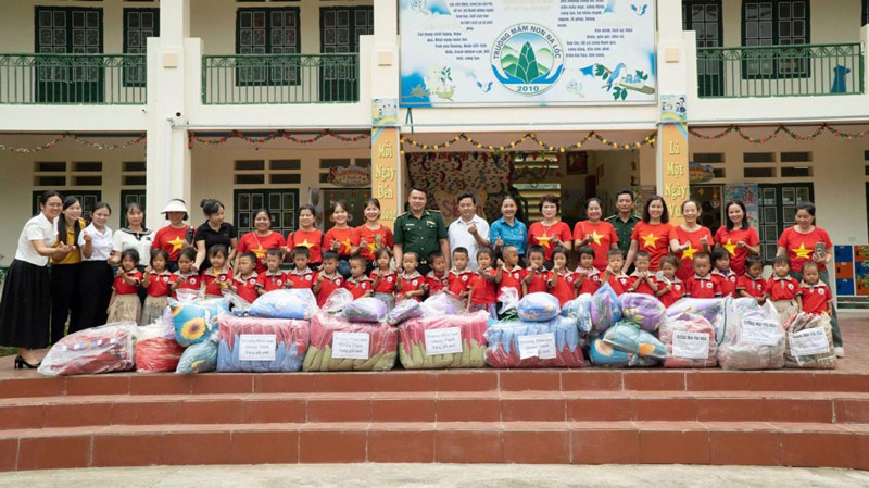 Muong Khuong District Trade Union and volunteer group give notebooks and clothes to students. Photo: Cao Pha