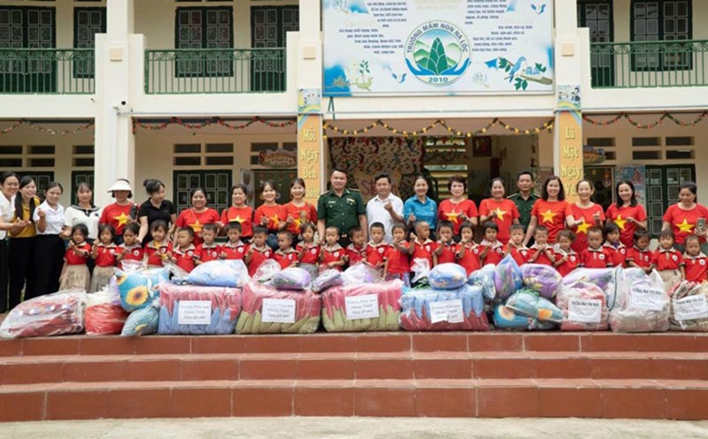 Muong Khuong District Trade Union and volunteer group give notebooks and clothes to students. Photo: Cao Pha
