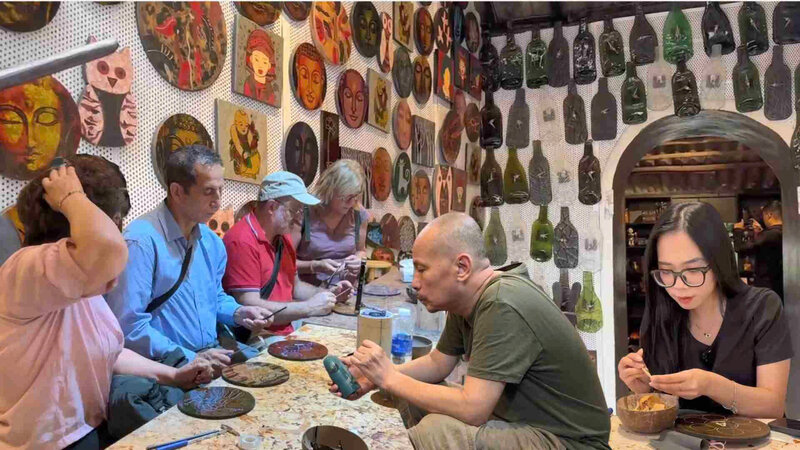 Tourists enjoy Ha Thai lacquer painting experience tour. Photo: Huyen Trang