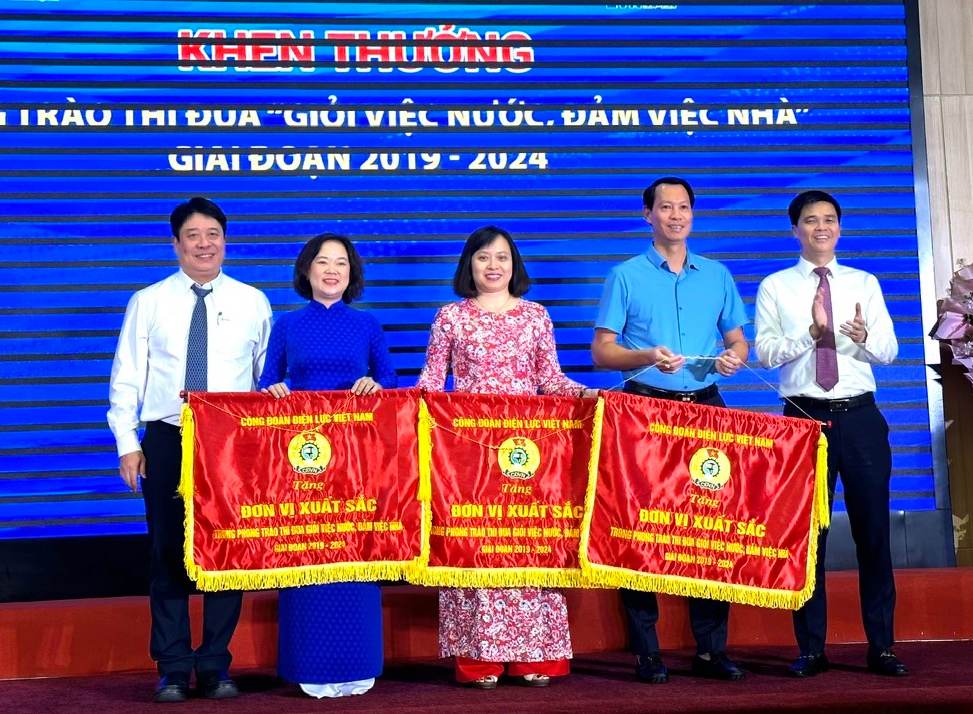 Phó Chủ tịch Tổng LĐLĐVN Ngọ Duy Hiểu (ngoài cùng, bên phải) và Tổng Giám đốc Tập đoàn Điện lực Việt Nam  Nguyễn Anh Tuấn (ngoài cùng, bên trái) trao Cờ thi đua của Công đoàn Điện lực Việt Nam cho các tập thể đạt thành tích cao trong phong trào thi đua "Giỏi việc nước - đảm việc nhà". Ảnh: Hà Anh