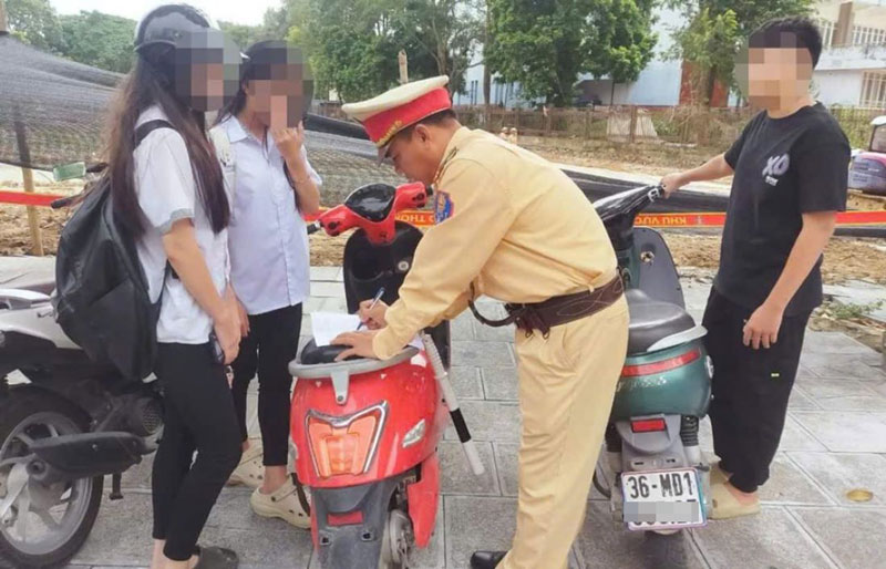 Lực lượng CSGT Thanh Hóa kiểm tra, xử phạt học sinh đi xe máy khi chưa đủ điều kiện. Ảnh: CATH