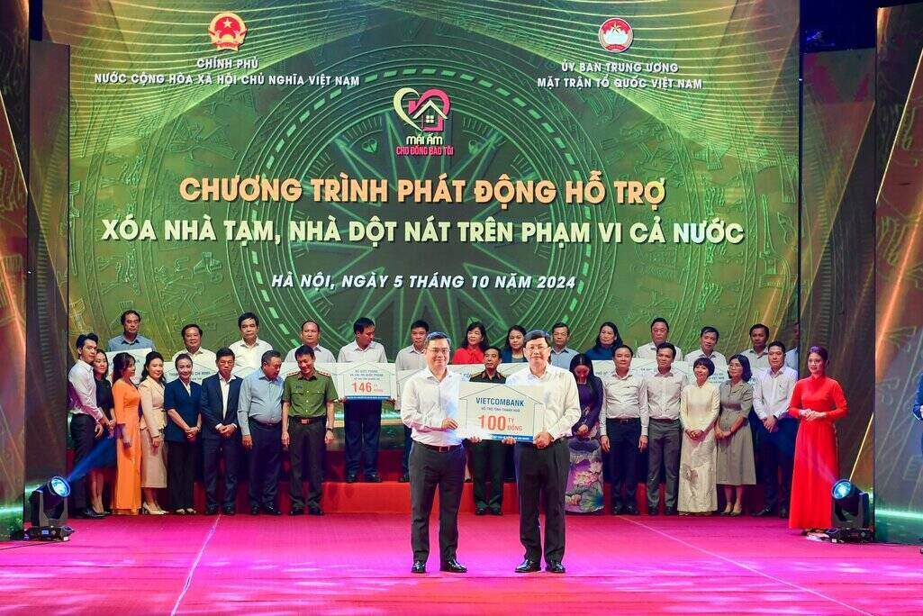 Ong Nguyen Thanh Tung (ben trai) – Bi thu Dang uy, Chu tich HDQT Vietcombank trao tuong trung kinh phi 100 ti dong ho tro xoa nha tam, nha dot nat ung ho cho dia phuong. Anh: Ban to chuc.