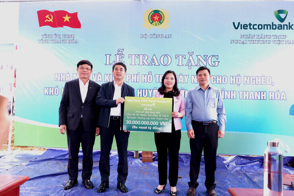 Thay mat Vietcombank, dong chi Nghiem Xuan Thanh, Uy vien Trung uong Dang, Bi thu Dang uy, Chu tich Hoi dong quan tri (thu 2 tu trai sang) va dong chi Dao Minh Tuan, Chu tich Cong doan, Pho Tong Giam doc trao 30 ty dong cho dai dien Uy ban Mat tran To quoc tinh Thanh Hoa de xay dung 600 can nha cho ho ngheo kho khan ve nha o tren dia ban huyen Muong Lat.