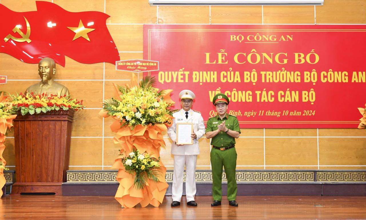Lieutenant General Nguyen Van Long - Deputy Minister of Public Security presented the decision and flowers to congratulate Colonel Nguyen Thanh Liem. Photo: Quang Binh Police