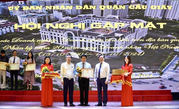 Pho Cuc truong Cuc Thue Ha Noi Phan Tien Hoa (thu 2 ben trai) va Chu tich UBND quan Cau Giay Bui Tuan Anh (thu 2 ben phai) vinh doanh cac doanh nghiep co nhieu dong gop vao su phat trien kinh te - xa hoi cua quan nam 2024. Anh: Van Trang 