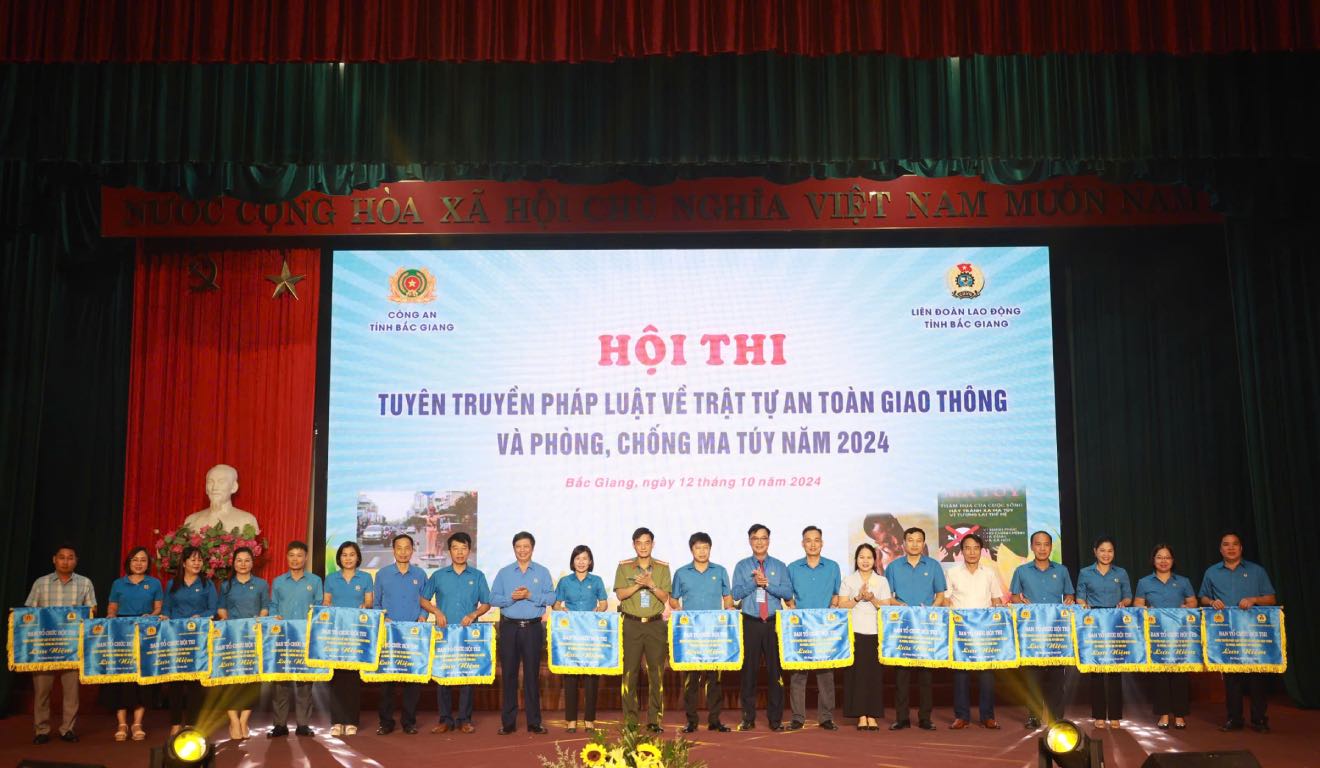 Leaders of the Bac Giang Provincial Labor Federation and Bac Giang Provincial Police presented souvenir flags to teams participating in the contest to propagate laws on traffic safety and order, and drug prevention. Photo: Quyet Chien