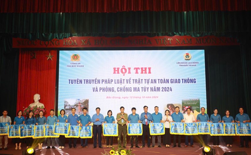 Leaders of the Bac Giang Provincial Labor Federation and Bac Giang Provincial Police presented souvenir flags to teams participating in the contest to propagate laws on traffic safety and order, and drug prevention. Photo: Quyet Chien