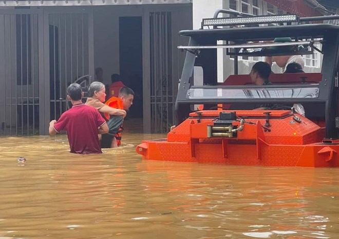 Luc luong chuc nang cung nguoi dan ho tro dua ba con khu vuc ngap sau den noi an toan. Anh: Bao Nguyen