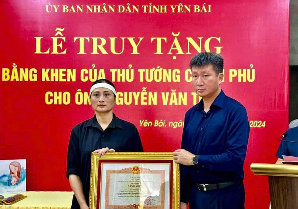 Mr. Tran Huy Tuan, Chairman of Yen Bai Provincial People's Committee, presented the Prime Minister's Certificate of Merit to the family representative of Mr. Nguyen Van Thi - who died while rescuing victims during the storm and flood. Photo: DVCC