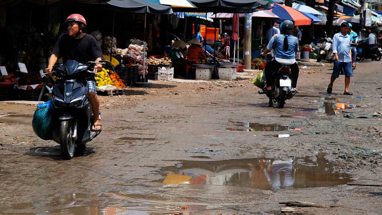 The road leading to Tan An market is dirty during the rainy season, and businesses are sluggish