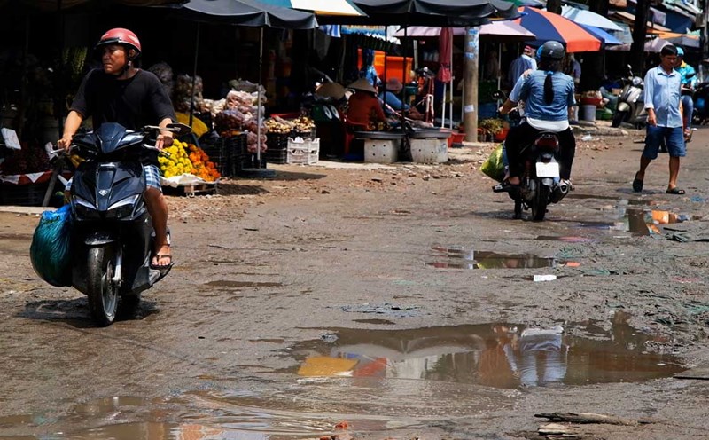 The road leading to Tan An market is dirty during the rainy season, and businesses are sluggish