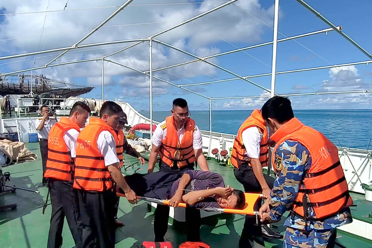 Officers and soldiers of Ship 418 transport fishermen from Tien Nu Island to Sinh Ton Island for emergency treatment. Photo: Truong Sa
