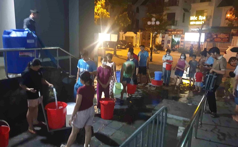 Người dân chung cư Gemek 1 xếp hàng xách nước sau bị mất nước. Ảnh: Vân Trường