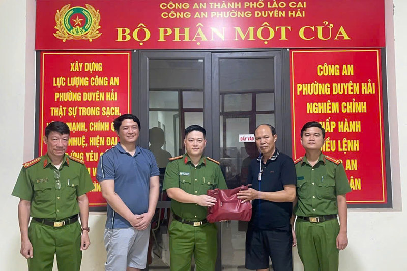 Mr. Phung Van Hieu (blue T-shirt) and the Duyen Hai Ward Police (Lao Cai City) returned the property to the person who lost it. Photo: Tong Hue