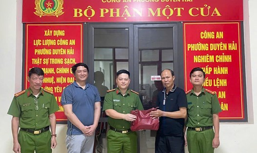 Anh Phùng Văn Hiểu (áo phông xanh) cùng Công an phường Duyên Hải (TP Lào Cai) trao trả lại tài sản cho người đánh rơi. Ảnh: Tống Huệ