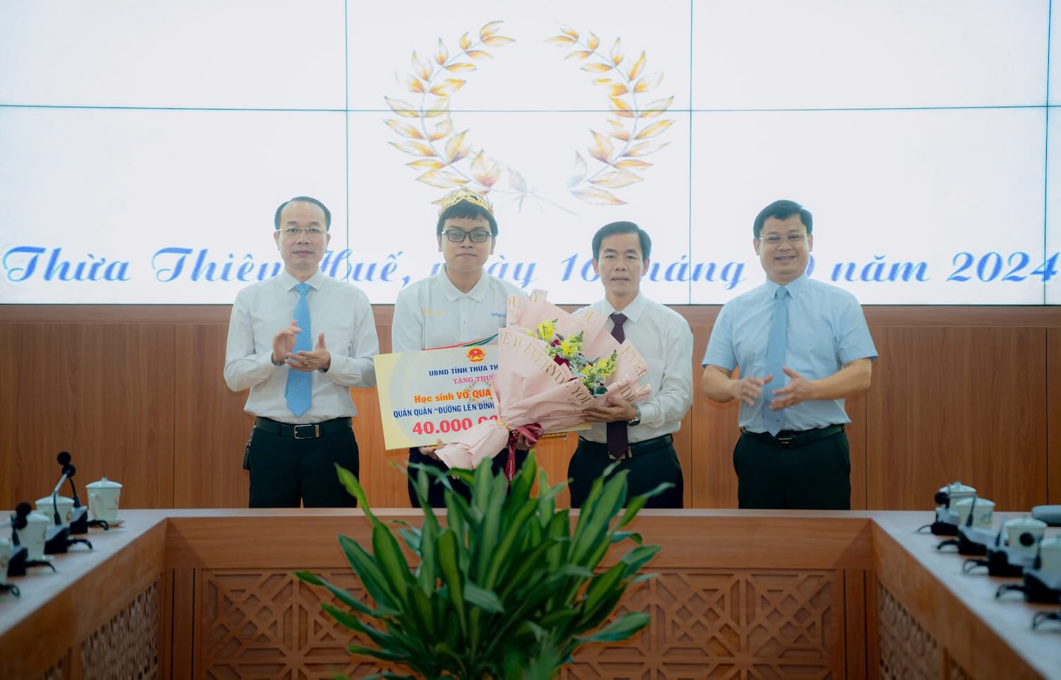 Chairman of Thua Thien Hue Provincial People's Committee Nguyen Van Phuong (second from right) presents flowers to congratulate the 2024 Olympia Champion. Photo: Ngoc Hieu.