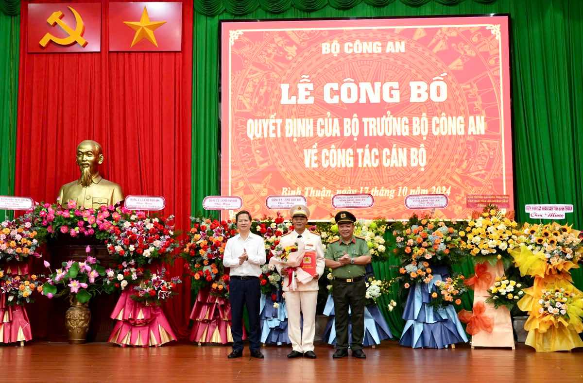 Dai ta Le Quang Nhan, Giam doc Cong an tinh Binh Thuan va ong Doan Anh Dung, Chu tich UBND tinh Binh Thuan trao hoa chuc mung va thua uy quyen cua Bo truong Bo Cong an trao Quyet dinh dieu dong cho Dai ta Nguyen Anh Tuan. Anh: Van Hoan