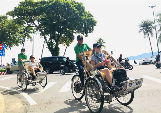 Khach du lich tau bien den Nha Trang khi len bo thuong tranh thu di tour xich lo tham quan thanh pho. Anh: Phuong Linh