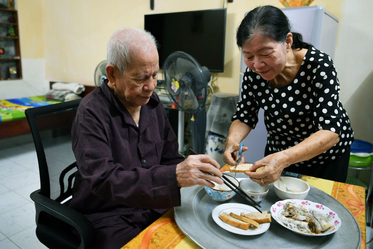 Ba Tran Thi Minh Anh, 81 tuoi dang lo bua sang cho chong la ong Tran Dinh Tuan, 95 tuoi. Chup tai khu tap the Kim Lien (Ha Noi).