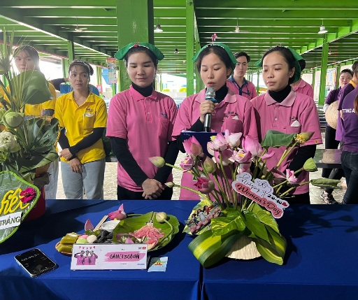 Female union members and workers present their flower arrangement contest and display their team's traditional cake tray. Photo: Thuy Hanh