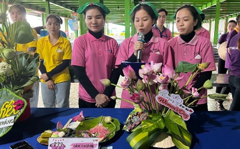 Female union members and workers present their flower arrangement contest and display their team's traditional cake tray. Photo: Thuy Hanh