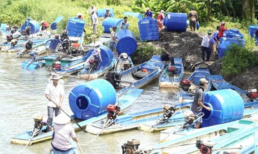 Bà con vùng hạn mặn huyện An Minh đến nhận bồn chứa nước. Ảnh: Nguyên Anh
