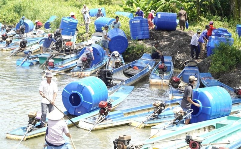 People in the drought-stricken and saline-affected areas of An Minh district come to receive water tanks. Photo: Nguyen Anh