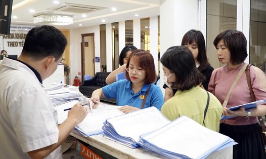 Cán bộ LĐLĐ quận Ba Đình hướng dẫn người lao động làm thủ tục khám sức khỏe miễn phí tại Bệnh viện Đa khoa Hòe Nhai. Ảnh: CĐCS