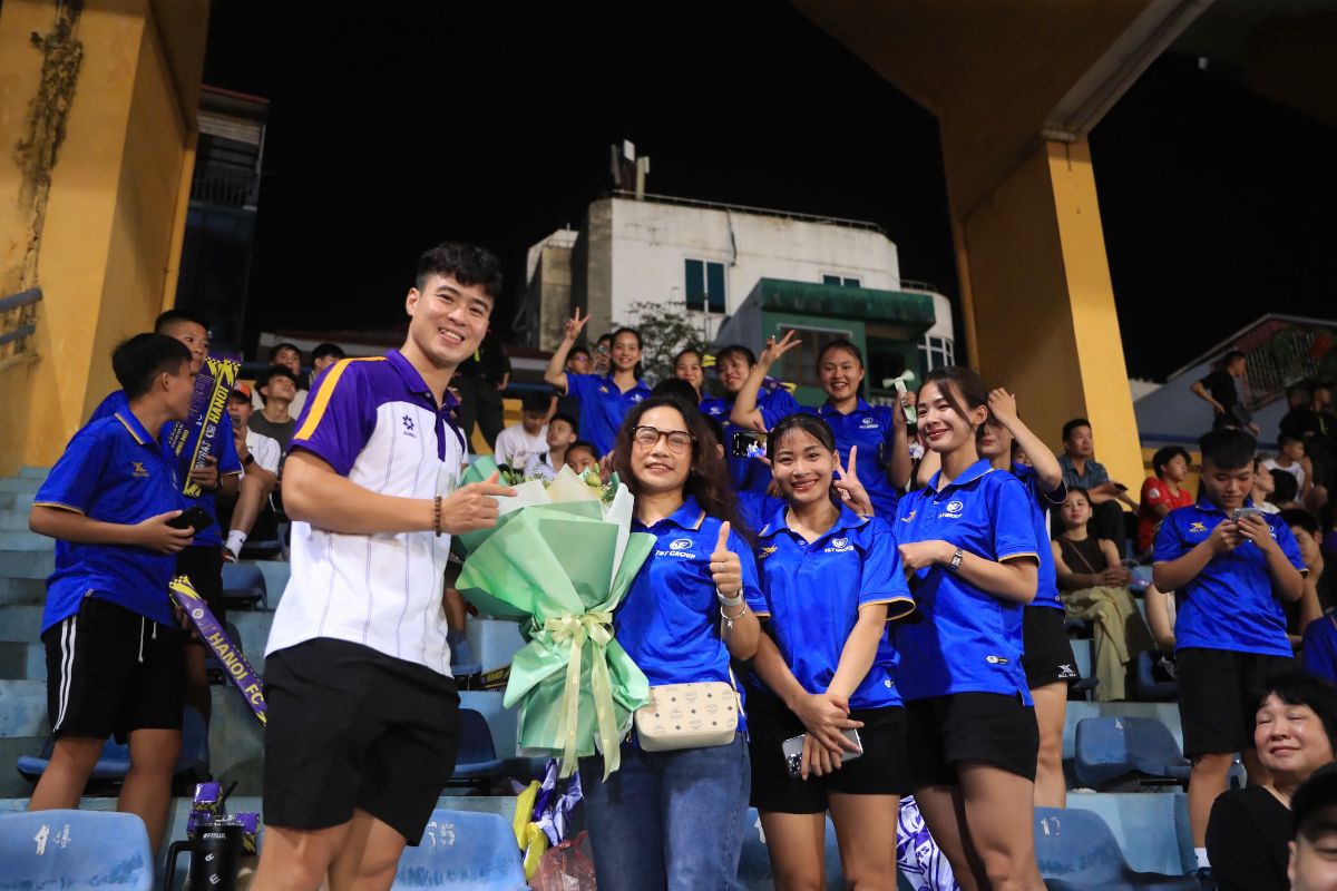 Hanoi FC's center back Do Duy Manh presents flowers to coach Van Thi Thanh and fans on October 20. Photo: HNFC